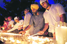 Mourners light candles at the Wisconsin gurdwara. 