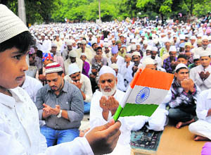 A boy holds an Indian flag as Muslims offer prayers on Eid at Jama Masjid in Chandigarh on Monday.