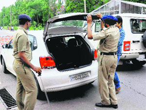 Panjab University security guards check the vehicles at the entrance gate No 2 in Chandigarh on Friday.
