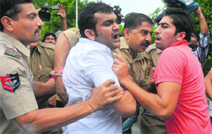 The police holds an INSO party member during a protest on the Kanda Issue near the Haryana Chief Minister’s residence in Chandigarh on Saturday.