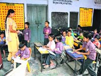 DISPLACED: Students of Government Primary School, Saini Majra, attend their classes in the corridor