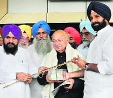Punjab Revenue Minister Bikram Singh Majithia (R) presents a memento to Home Minister Sushil Shinde (C) at Attari on Sunday.