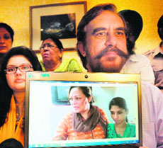 Pakistan human rights activist Ansar Burney shows a photograph of Geeta (right) in Amritsar on Saturday.