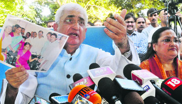 Union Law Minister Salman Khurshid with wife Louise shows photographs of relief camps organised by their NGO on Sunday. 