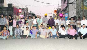 Shopkeepers stage a dharna on the National road in Ludhiana on Tuesday