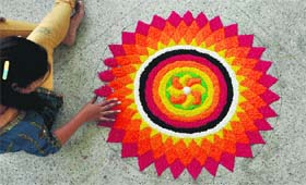 A student makes a rangoli