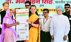 UPA chairperson Sonia Gandhi and PM Manmohan Singh hand over the 21st crore Aadhaar card to Bali Bai, who hails from Udaipur district, at Dudu near Jaipur on Saturday