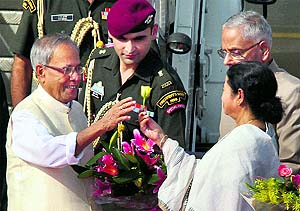 West Bengal Chief Minister Mamata Banerjee welcomes President Pranab Mukherjee at the Kolkata airport on Saturday as Governor MK Narayanan looks on