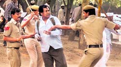 Police act against an IAC activist protesting outside Hoodas Delhi residence.