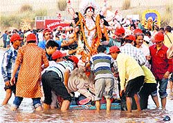 Devotees immerse an idol of Goddess Durga at Ghaggar in Panchkula on Wednesday