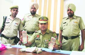 Beant Juneja, in charge, PCR, shows the hawala money seized from the accused in Ludhiana on Tuesday