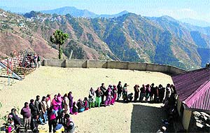People stand in a queue to cast their votes at Devrighat, 30 km from Shimla, on Sunday