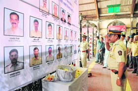 A police officer pays his respects to police and uniformed personnel who lost their lives in the 2008 terror attacks outside a railway station in Mumbai, on Monday