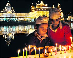 Children light candles to celebrate the birth anniversary of Guru Nanak Dev at the Golden Temple in Amritsar on Wednesday