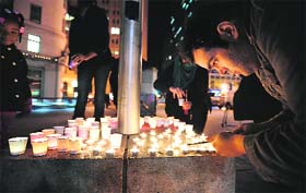 People light candles in memory of victims of the Connecticut school shooting in Oakland, California