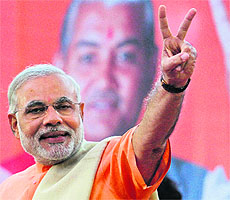Narendra Modi gestures on the podium during a felicitation ceremony outside the party office in Ahmedabad.