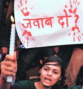 A student takes part in a candle-light march at Sector 17 in Chandigarh on Saturday
