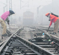Railway employees repair a track near Amritsar railway station on Tuesday. 