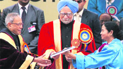 West Bengal CM Mamata Banerjee presents a copy of book The Balancing Act to President Pranab Mukherjee as PM Manmohan Singh looks on in Kolkata on Thursday.  PTI