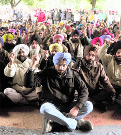 PAU employees hold a protest in support of their demands outside the Thapar Hall in Ludhiana on Thursday.