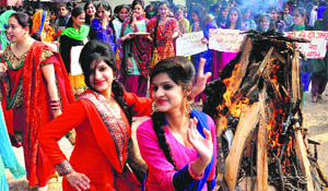 Girls dance around a bonfire during the Lohri celebrations at MCM College in Chandigarh on Saturday.