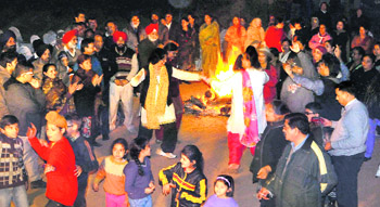 Praying for prosperity Residents dance around a bonfire to celebrate Lohri at Sector 44 in Chandigarh on Sunday.