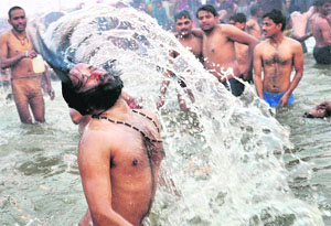 A sadhu takes a holy dip at Sangam in Allahabad on Monday. Tribune photo: Mukesh Aggarwal