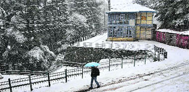 A man walks on a snow-covered street in Shimla on Thursday.