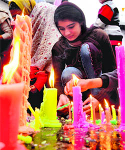 A girl lights a candle at a gurdwara on the occasion of the birth anniversary of Guru Gobind Singh in Ludhiana on Friday.