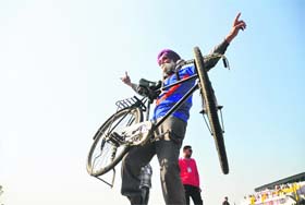 Gurnam Singh lifts a bicycle with his teeth