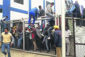 Spectators jump over the gate to gain entry to Guru Nanak Stadium in Ludhiana