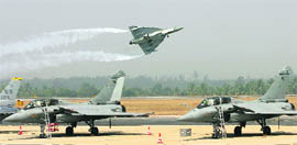 An LCA Tejas flies past two French Rafale fighter jets as it displays low-flying aerobatic skills in Bangalore on Thursday.