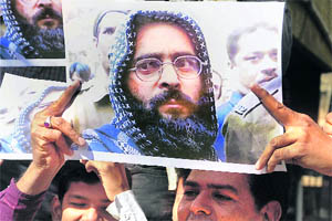 People hold placards of Afzal Guru after his hanging in Ahmedabad on Saturday. 