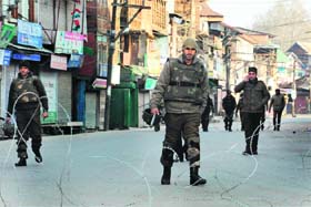 UNEASY CALM: Security personnel patrol a deserted street in Srinagar on Sunday