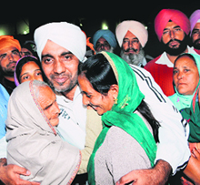 One of the 17 youths who returned from the UAE meets his family at the Golden Temple in Amritsar on Tuesday.
