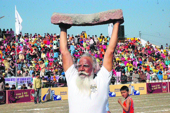 An elderly man proudly displays his physical strength at Kila Raipur. Even as farm machinery has reduced physical labour, many Punjabis keep themselves fit and look forward to show their skills in rural sports