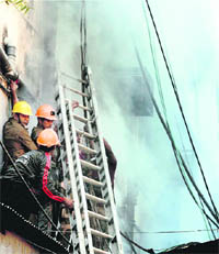 Firemen place a ladder to rescue trapped people after a fire broke out in a Kolkata market on Wednesday.