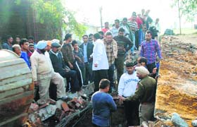 Onlookers at the site of the collapsed godown in Sarhal Mandi on Wednesday