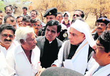 BJP chief Rajnath Singh interacts with farmers at a village in Aurangabad on Monday.