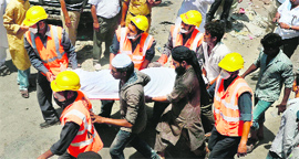 Rescue workers carry a body  from the site of a building collapse in Thane on Friday.