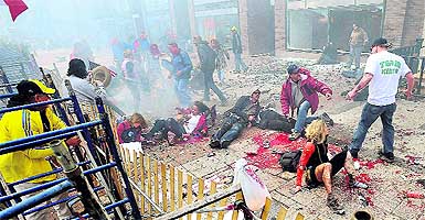 Injured people lie on the sidewalk near the Boston Marathon finish line after the blasts