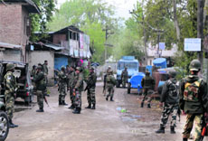  Paramilitary men inspect the spot were militants struck in Sopore on Friday. 