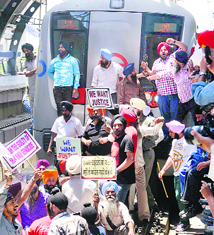 Protesters stop a Metro train at Tilak Nagar station in New Delhi on Wednesday.