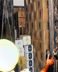 A police official opens the door of House No. 1677 at Dadu Majra Colony to count liquor boxes stacked illegally there on Friday night