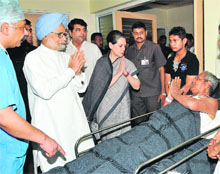 PM Manmohan Singh and Congress chief Sonia Gandhi meet an injured person at a hospital in Raipur. 