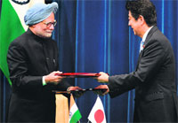 PM Manmohan Singh and his Japanese counterpart Shinzo Abe exchange documents in Tokyo on Wednesday.  AFP