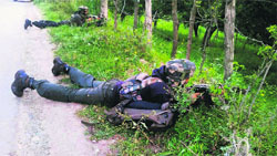 Army soldiers take position near the encounter site in the Kellar area of Pulwama district on Thursday.