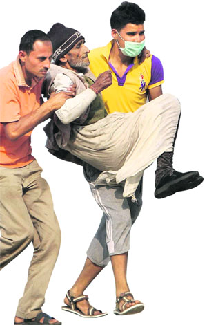 A rescued pilgrim is helped by NDRF personnel at Guptakashi near the flood-hit Kedarnath shrine.