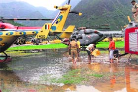 Fire brigade personnel drain out water from Gauchar air strip following heavy rains that halted rescue operations by the Army and the IAF on Monday
