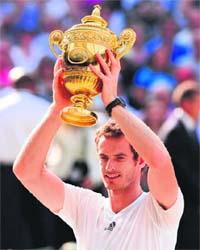 Britains Andy Murray celebrates with the trophy after defeating Novak Djokovic in the Wimbledon final in London
